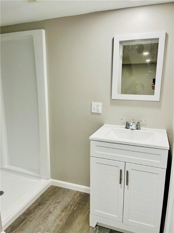 74 Leslie St, Cranston, RI 02910 - bathroom featuring wood finished floors, vanity, and a shower