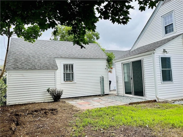 74 Leslie St, Cranston, RI 02910 - back of property with a shingled roof and a patio