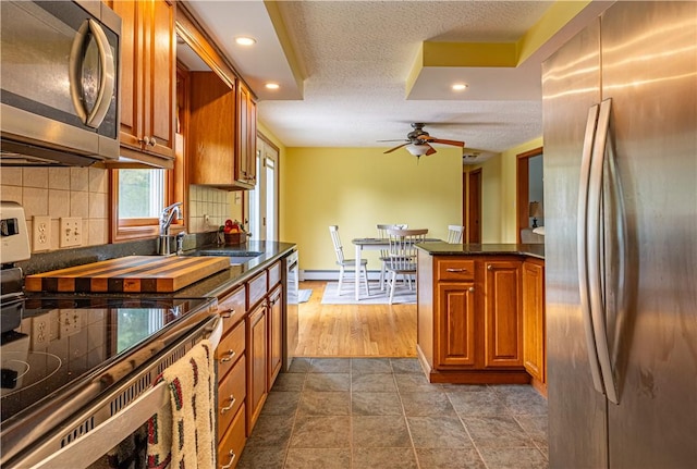 1846 E Wallum Lake Rd, Burrillville, RI 02859 - kitchen with appliances with stainless steel finishes, ceiling fan, tasteful backsplash, recessed lighting, and brown cabinetry
