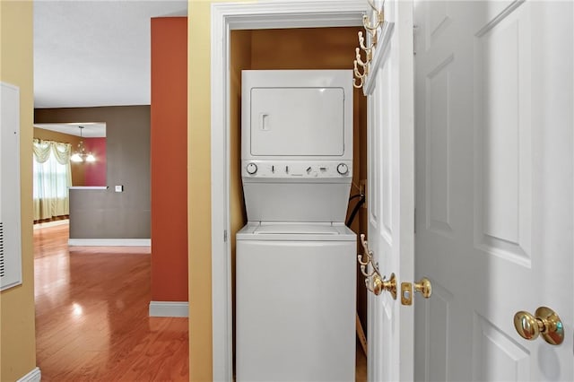 120 Mill St Unit 103, Woonsocket, RI 02895 - laundry room with stacked washer / dryer and wood finished floors