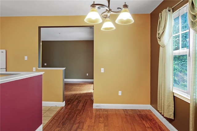 120 Mill St Unit 103, Woonsocket, RI 02895 - unfurnished dining area with a chandelier, plenty of natural light, and wood finished floors