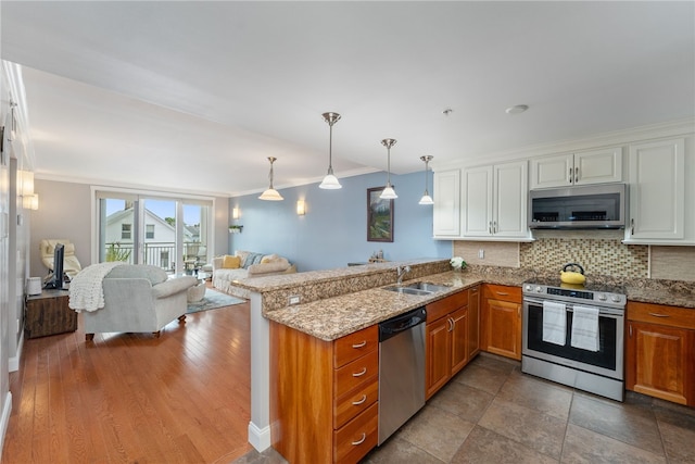 333 Atwells Ave Unit 302, Providence, RI 02903 - kitchen featuring appliances with stainless steel finishes, crown molding, brown cabinetry, open floor plan, and a peninsula