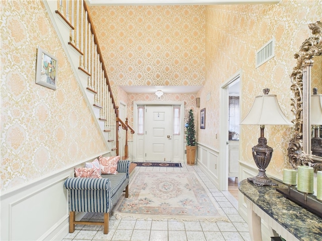 150 Central Ave, Johnston, RI 02919 - entrance foyer featuring stairs, wallpapered walls, light tile patterned floors, a decorative wall, and wainscoting