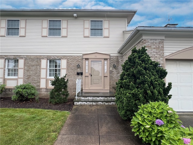 150 Central Ave, Johnston, RI 02919 - view of front of house with brick siding and a garage