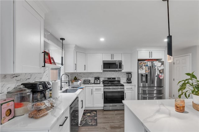 8 Gale Ct, North Providence, RI 02904 - kitchen featuring stainless steel appliances, wood finished floors, white cabinetry, decorative backsplash, and pendant lighting