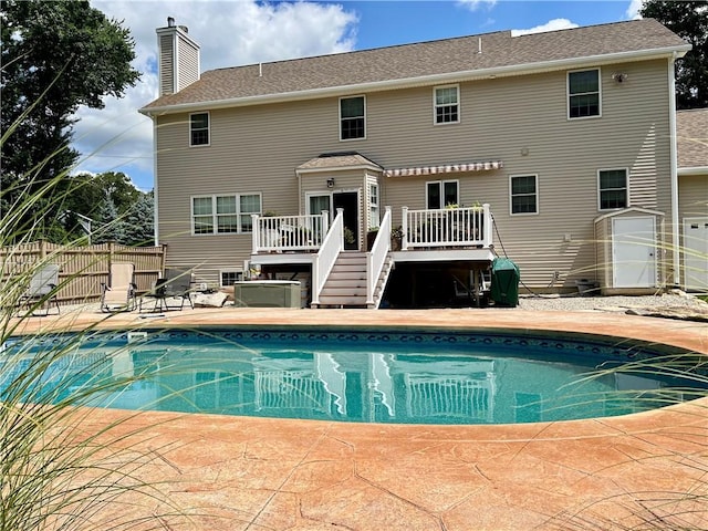 35 E Lantern Rd, Smithfield, RI 02917 - back of property featuring a wooden deck, an outdoor pool, a chimney, and a patio area