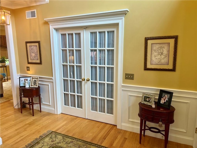 35 E Lantern Rd, Smithfield, RI 02917 - doorway with a decorative wall, a chandelier, wood finished floors, and wainscoting