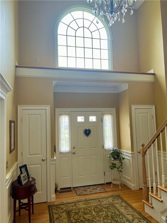 35 E Lantern Rd, Smithfield, RI 02917 - entrance foyer with a towering ceiling, stairway, wood finished floors, healthy amount of natural light, and a wainscoted wall