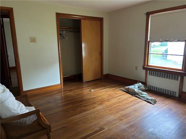 12 Oakland Ave, Johnston, RI 02919 - bedroom featuring radiator heating unit, wood finished floors, and a closet