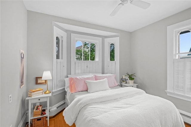 303 Angell St Unit 3, Providence, RI 02906 - bedroom with wood finished floors, a baseboard heating unit, and a ceiling fan