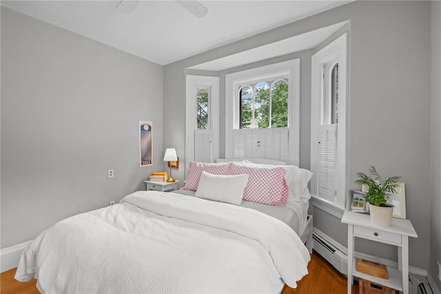 303 Angell St Unit 3, Providence, RI 02906 - bedroom featuring wood finished floors, a baseboard radiator, and a ceiling fan