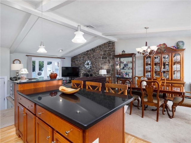 184 Vallette St, Cranston, RI 02920 - kitchen with dark countertops, brown cabinetry, a chandelier, a kitchen island, and light wood-style floors