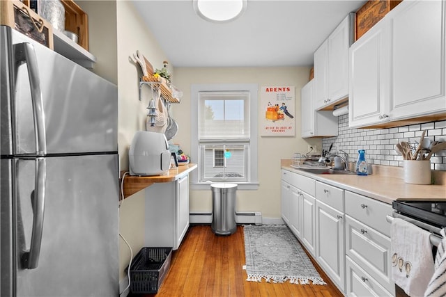 13 Dean Ave, Newport, RI 02840 - kitchen featuring stainless steel appliances, a baseboard heating unit, decorative backsplash, light countertops, and white cabinets
