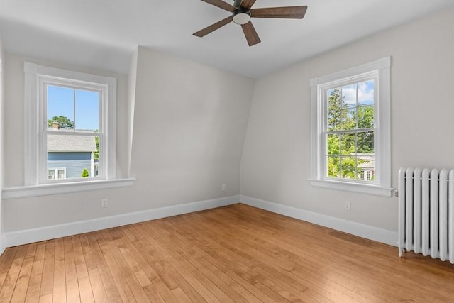 11 Taft St, Coventry, RI 02816 - empty room featuring radiator heating unit, light wood finished floors, and a ceiling fan