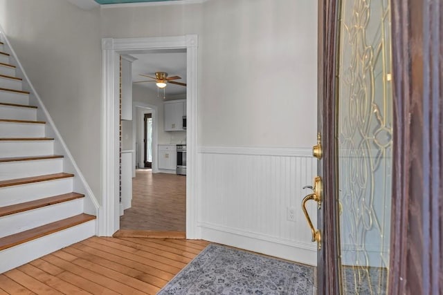 11 Taft St, Coventry, RI 02816 - entryway featuring stairs, light wood finished floors, wainscoting, and ceiling fan