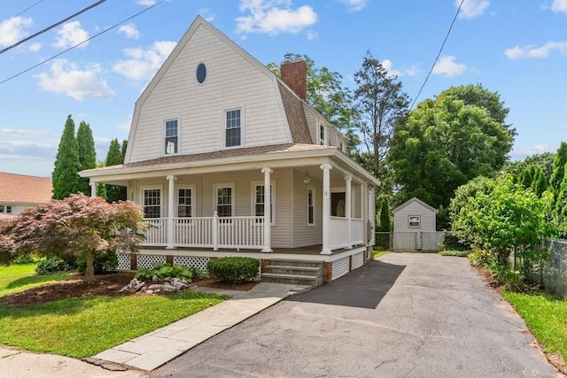 11 Taft St, Coventry, RI 02816 - view of front of property with a porch, a gambrel roof, a chimney, and asphalt driveway