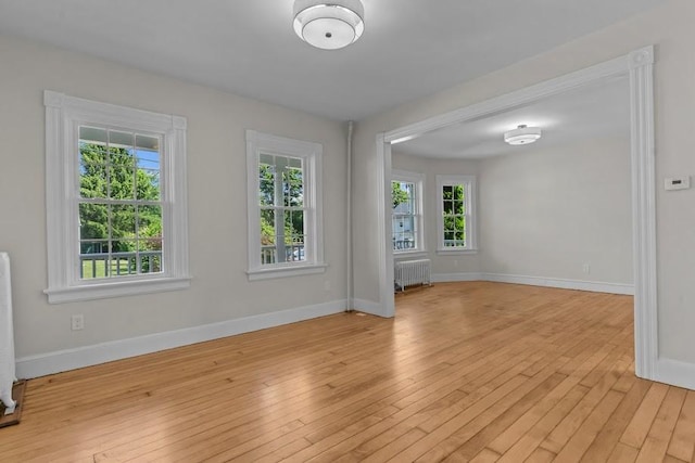 11 Taft St, Coventry, RI 02816 - empty room with light wood finished floors and radiator heating unit