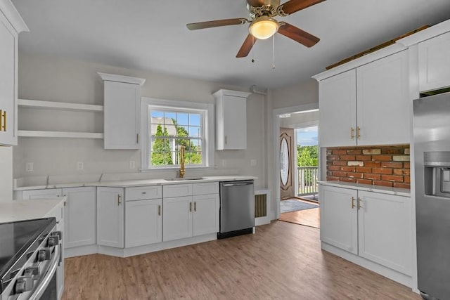 11 Taft St, Coventry, RI 02816 - kitchen featuring appliances with stainless steel finishes, light countertops, light wood-style floors, open shelves, and white cabinets