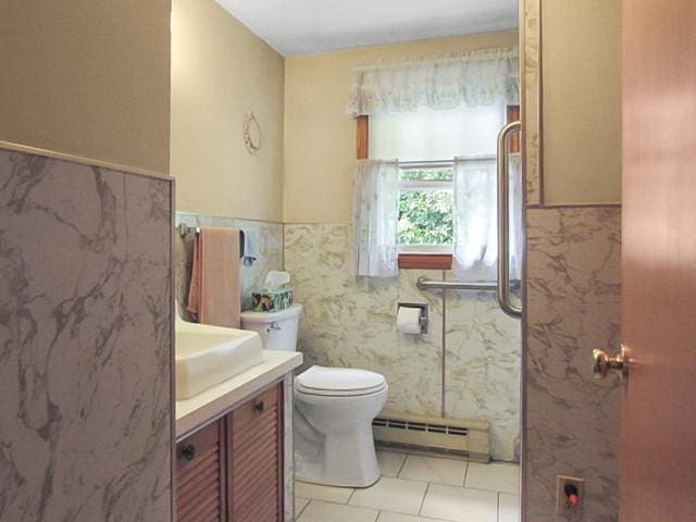 21 Hemlock Ave, Cranston, RI 02910 - bathroom with a baseboard radiator, vanity, a wainscoted wall, and tile patterned floors