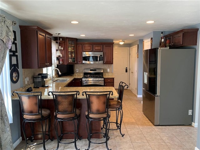 50 Paliotta Pkwy, Cranston, RI 02921 - kitchen with appliances with stainless steel finishes, a peninsula, decorative backsplash, glass insert cabinets, and light tile patterned floors