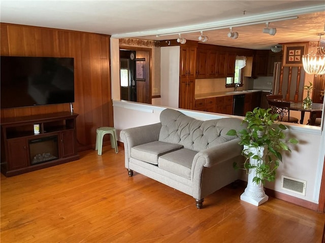 19 Leawood Dr, Cranston, RI 02920 - living area with light wood-style flooring, a chandelier, wood walls, and rail lighting