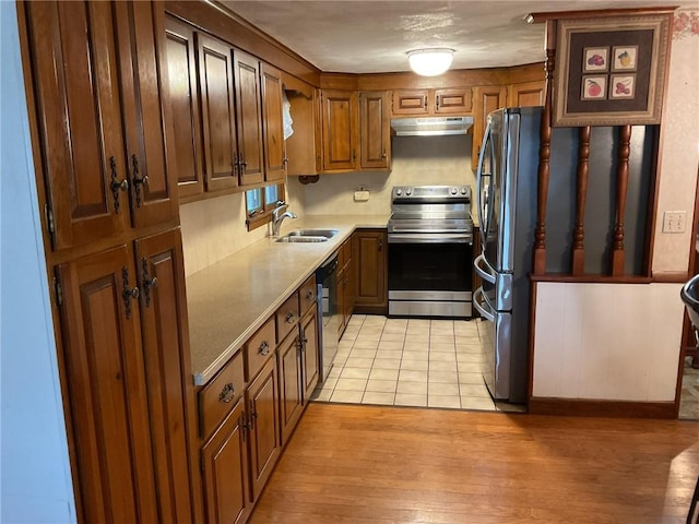 19 Leawood Dr, Cranston, RI 02920 - kitchen with appliances with stainless steel finishes, under cabinet range hood, light wood-style flooring, brown cabinetry, and light countertops