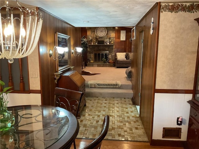 19 Leawood Dr, Cranston, RI 02920 - living area featuring a chandelier, wooden walls, and a stone fireplace