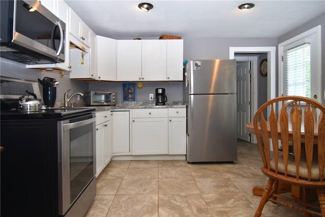 32 Harrington Dr, Johnston, RI 02919 - kitchen featuring appliances with stainless steel finishes, white cabinetry, light stone counters, and light tile patterned floors