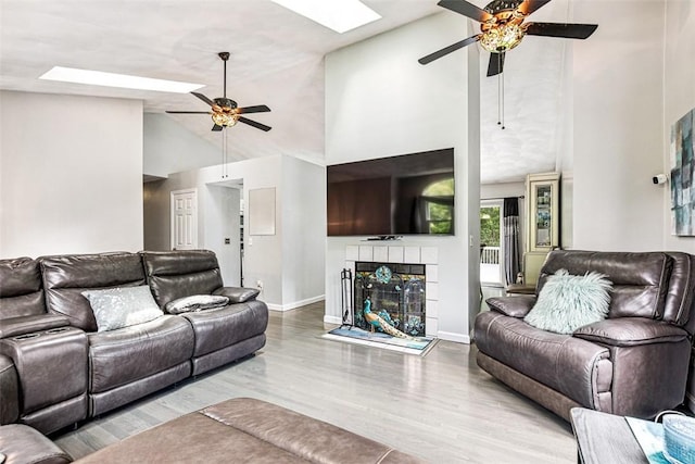 9 Ivy Hollow Ct, Cranston, RI 02921 - living area featuring a ceiling fan, high vaulted ceiling, wood finished floors, a tiled fireplace, and a skylight