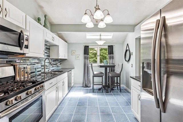9 Ivy Hollow Ct, Cranston, RI 02921 - kitchen with stainless steel appliances, decorative backsplash, white cabinetry, a chandelier, and dark stone countertops