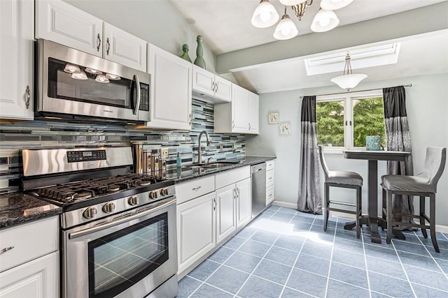 9 Ivy Hollow Ct, Cranston, RI 02921 - kitchen featuring stainless steel appliances, backsplash, white cabinets, a chandelier, and dark stone counters