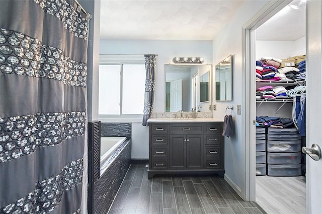 9 Ivy Hollow Ct, Cranston, RI 02921 - bathroom featuring vanity, a bath, wood finished floors, and a walk in closet