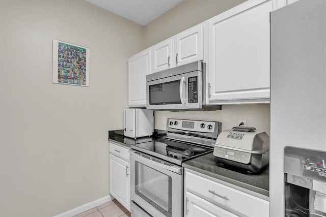 1000 Providence Pl Unit 201, Providence, RI 02903 - kitchen featuring appliances with stainless steel finishes, white cabinets, dark countertops, and light tile patterned floors