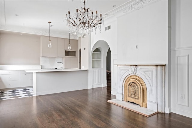157 Waterman St Unit 2-5, Providence, RI 02906 - unfurnished living room with arched walkways, built in shelves, ornamental molding, a chandelier, and wood finished floors
