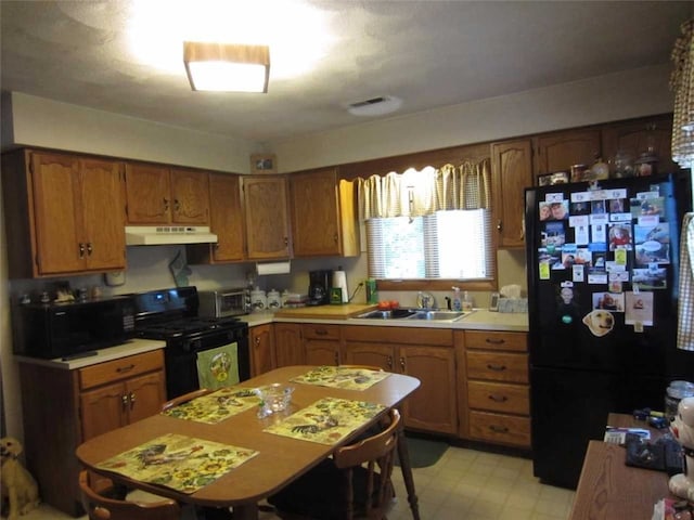 kitchen with sink, light tile floors, and black appliances