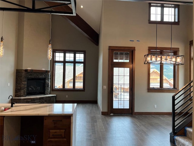 interior space featuring a fireplace, beamed ceiling, high vaulted ceiling, and dark wood-type flooring