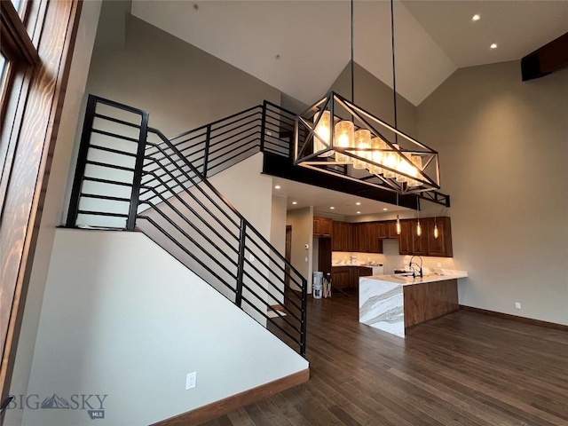 27A Heavy Runner Rd Unit 27A, Big Sky, MT 59716 - kitchen with high vaulted ceiling, refrigerator, light countertops, dark wood-style flooring, and a peninsula