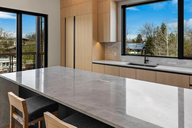 kitchen featuring light brown cabinets, a sink, and modern cabinets