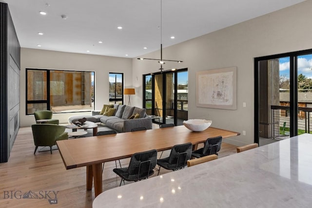 dining area with light wood-style floors, a wealth of natural light, and recessed lighting