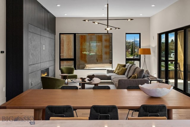 dining area featuring a large fireplace, an inviting chandelier, and recessed lighting