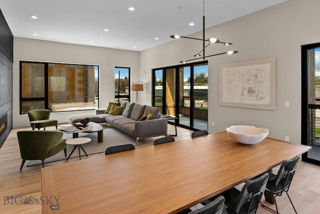 dining room featuring recessed lighting, a large fireplace, and light wood finished floors