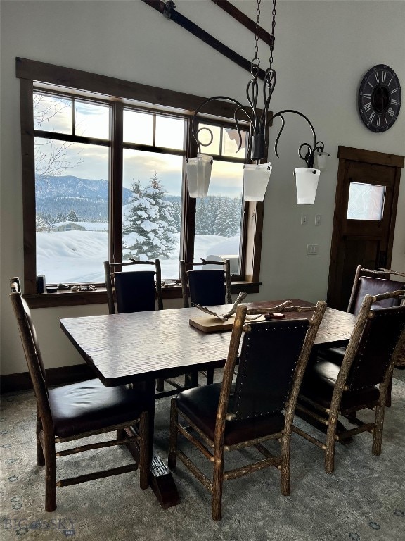 dining area with vaulted ceiling, a chandelier, and a mountain view