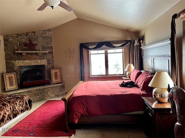 bedroom featuring ceiling fan, vaulted ceiling, dark colored carpet, and a fireplace