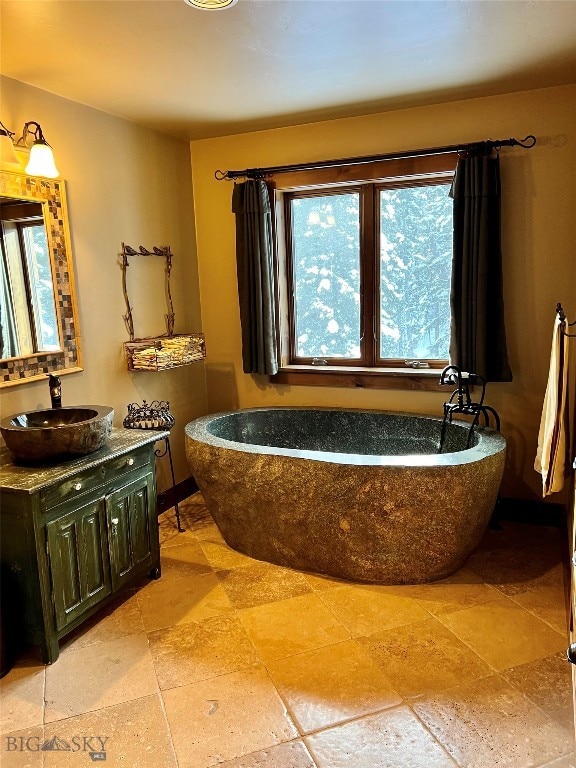 bathroom featuring tile flooring, vanity, and a bath to relax in