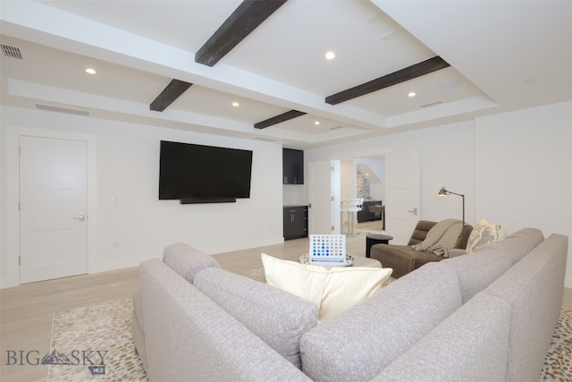 living room featuring beamed ceiling and light wood-type flooring