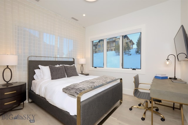 bedroom featuring light hardwood / wood-style floors and tile walls