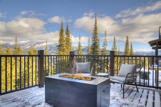 deck with a mountain view and a fire pit