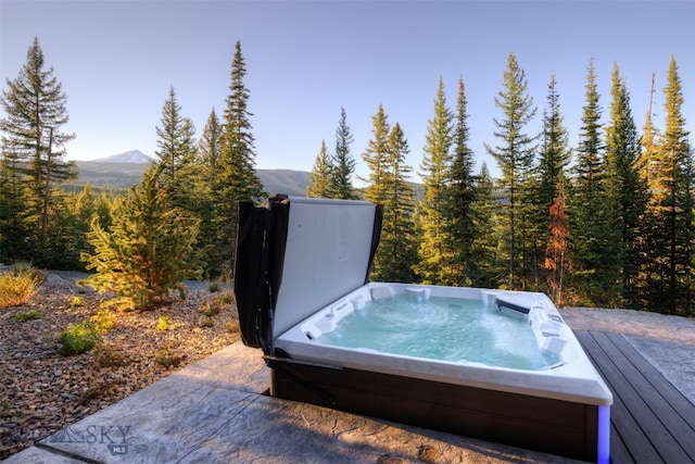 exterior space featuring a mountain view and a hot tub