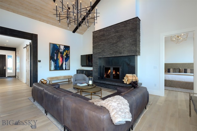 living room featuring a fireplace, a towering ceiling, and light wood-type flooring