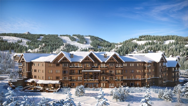 snow covered building featuring a mountain view